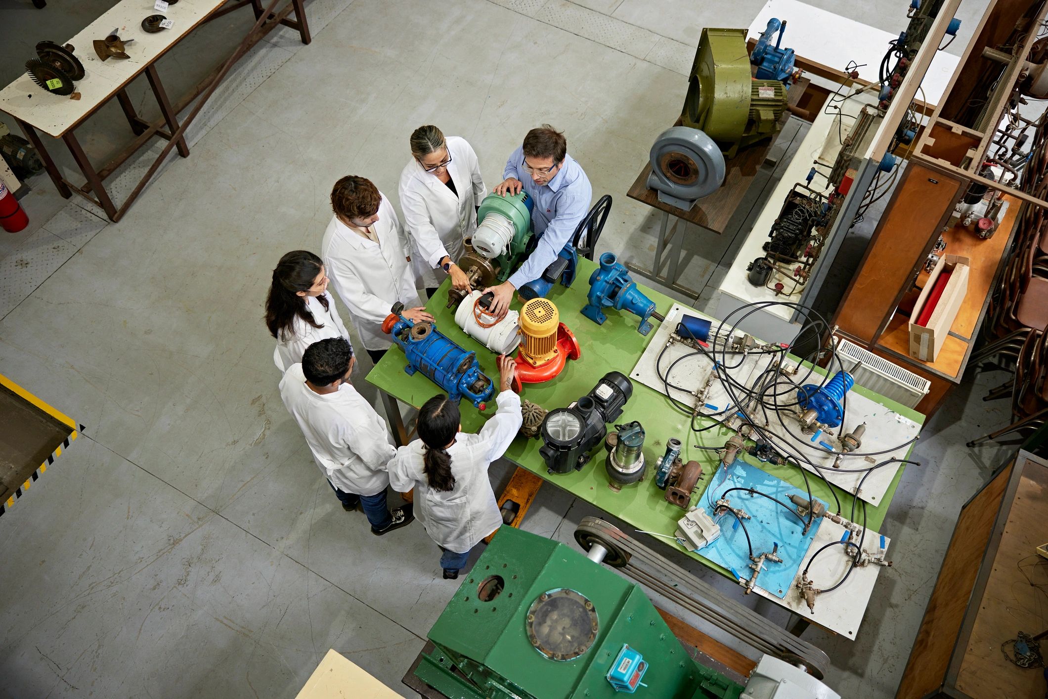 Instructor and students gathered around equipment in a training lab