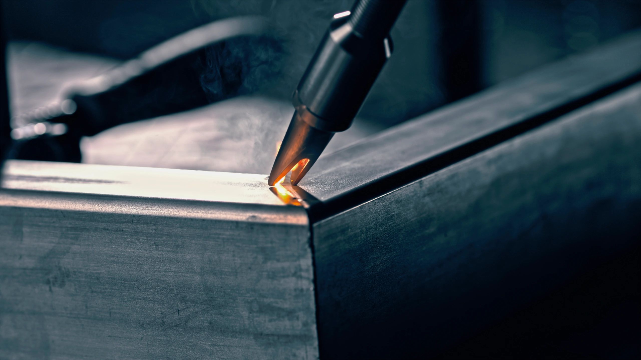 Close-up of a welding torch on metal with sparks